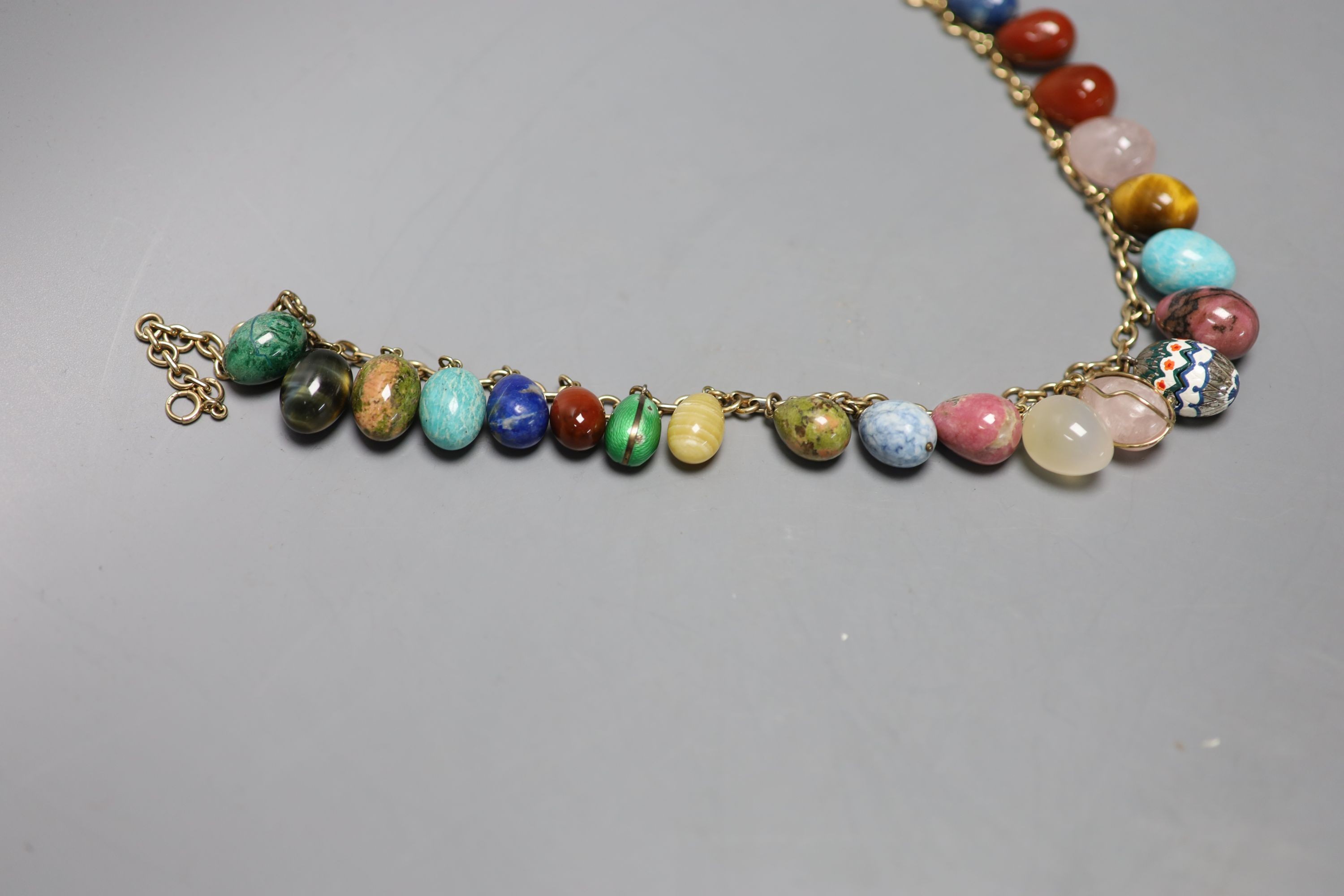 A 9ct gold and egg shaped specimen hardstone and enamelled charm set necklace, 70cm, gross weight 198.6 grams.